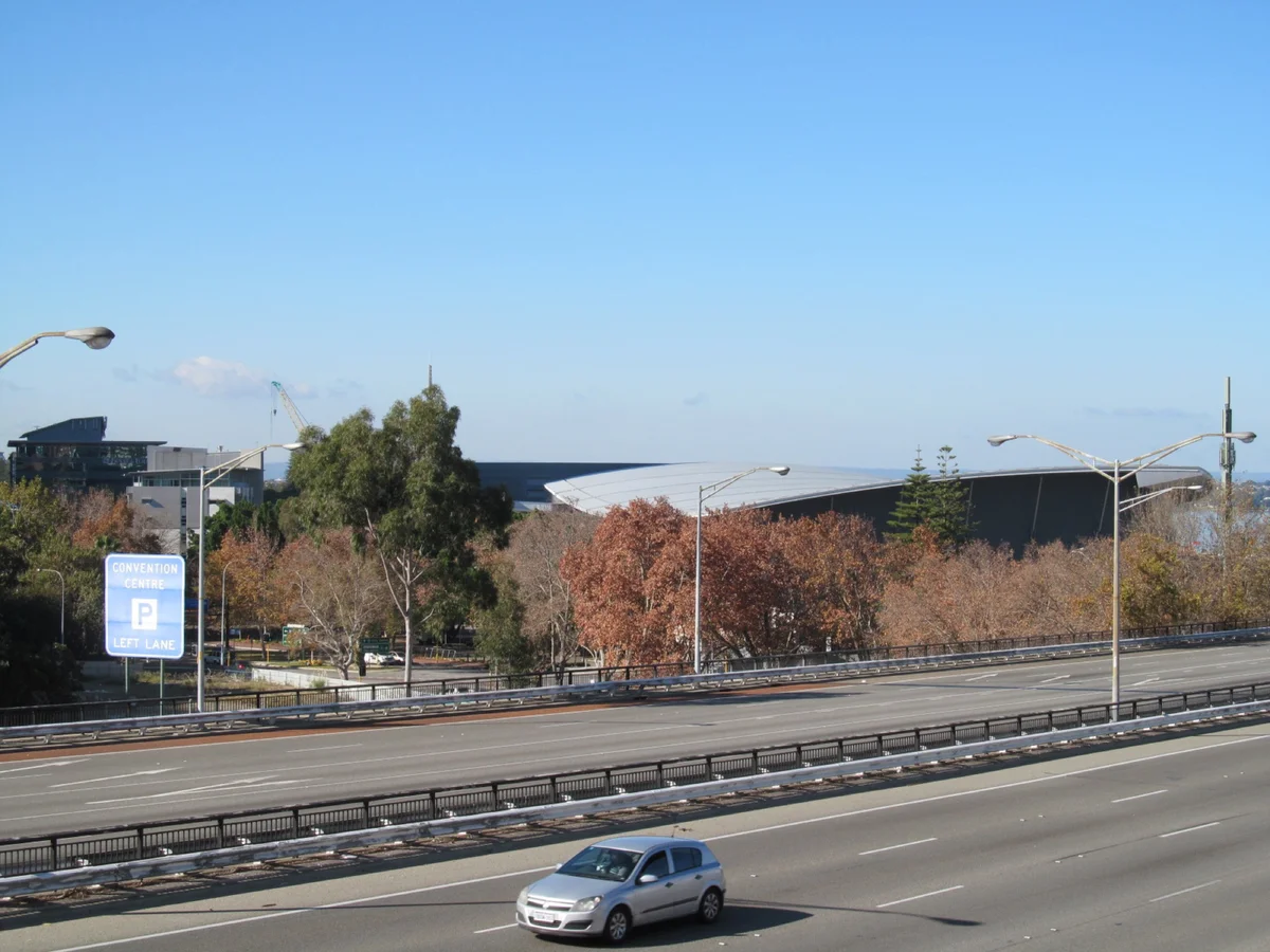 The Perth Convention and Exhibition Centre seen from the Mount Street footbridge over the Mitchell Freeway, with a Convention Centre parking sign in the foreground