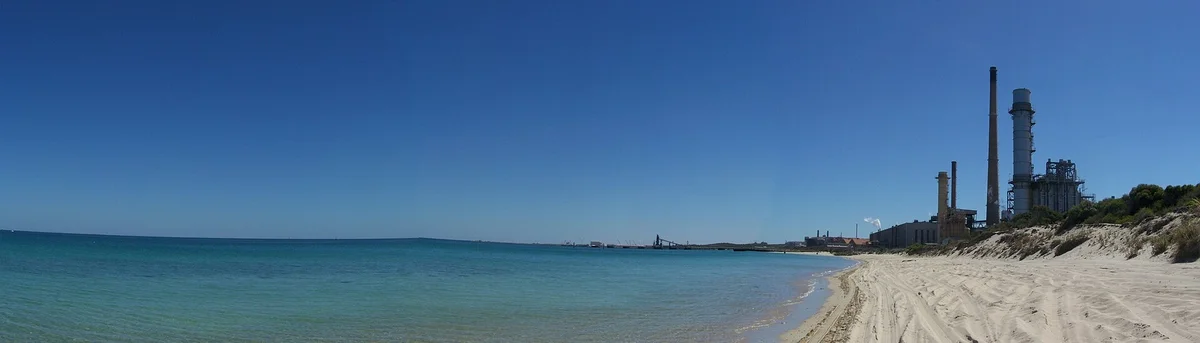 Panorama of a beach with Kwinana Power Station chimneys in the distance