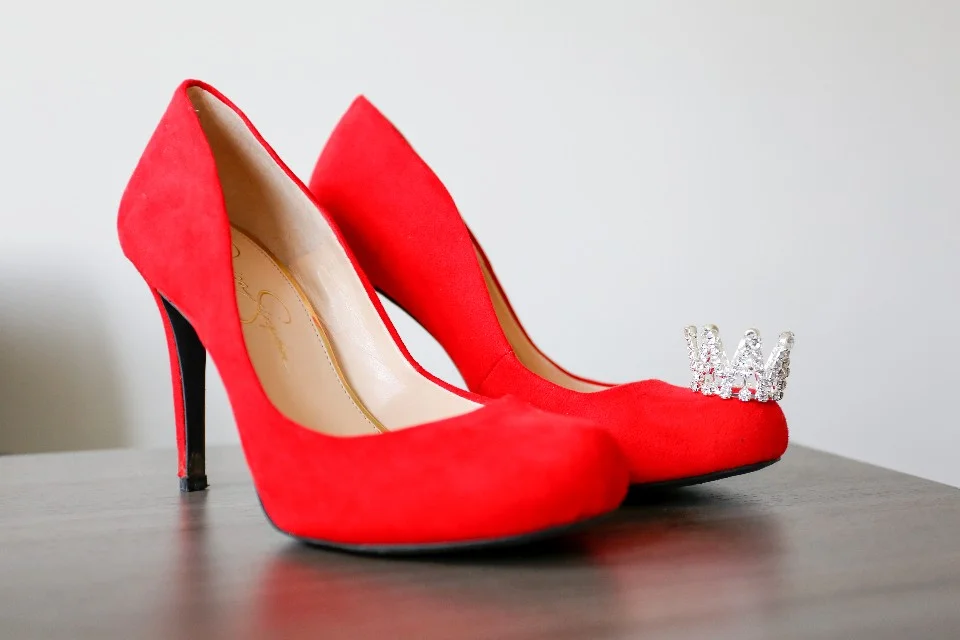 A pair of bright red suede high heels on a table